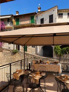 a patio with tables and chairs under an umbrella at B&B Casa Olivia in Gardone Riviera