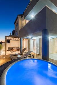 a swimming pool in front of a house at Modern Penthouse Split with Jacuzzi & Terrace in Split