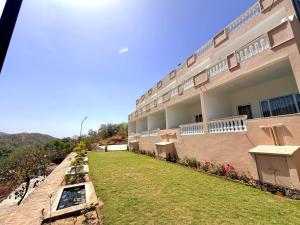 a building with a grass yard in front of it at JD Tara Resort in Ranakpur +9 photos