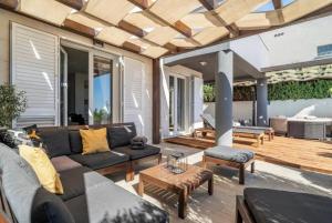 a patio with a couch and a table at Modern Penthouse Split with Jacuzzi & Terrace in Split