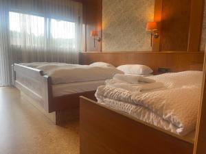 two beds in a hotel room with a mirror at Hotel Waldblick BSR Garten mit Pavillons im Schwarzwald, ideal für Paare, Familien, Hunde in Donaueschingen +188 photos