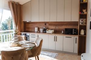 a kitchen with white cabinets and a table and chairs at Villa View Mostar with Heated Pool & Jacuzzi in Mostar +40 photos