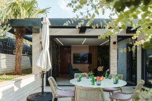 a patio with a table and chairs and an umbrella at Villa View Mostar with Heated Pool & Jacuzzi in Mostar