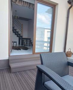 a porch with a chair and a large window at Pokoje J&J in Grabówka