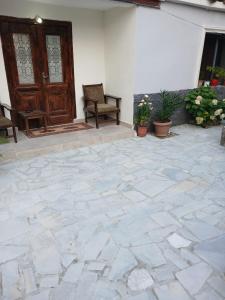 a patio with a wooden door and chairs and plants at Home in village in Korçë