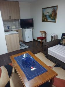 a living room with a coffee table and a bed at Home in village in Korçë