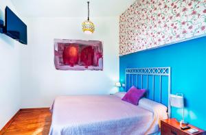 a bedroom with a bed and a painting on the wall at El Regreso in Jarilla