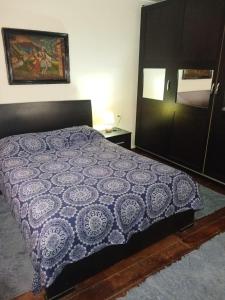 a bedroom with a bed with a blue and white bedspread at Home in village in Korçë +5 photos