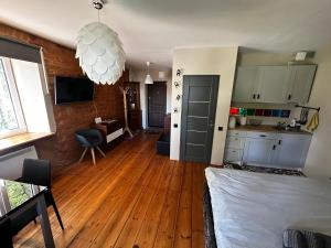 a living room with a wooden floor and a kitchen at R.Wolf castle in Gulbene