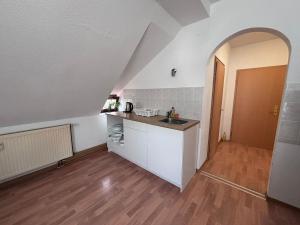 an attic kitchen with a sink and a counter at Comfortable and functional apartment in Kretzschau +9 photos