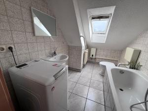 a bathroom with a sink and a tub and a toilet at Comfortable and functional apartment in Kretzschau