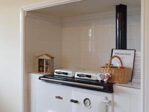 a kitchen with a stove and a basket at Pengelli Cottage in Eglwyswrw