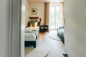 a living room with a bed and a window at 120sqm Duplex Apartment with AirC Free Parking Family & Business in Biel +69 photos