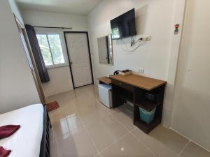 a bedroom with a desk and a sink in a room at Kitty Guesthouse in Phi Phi Islands