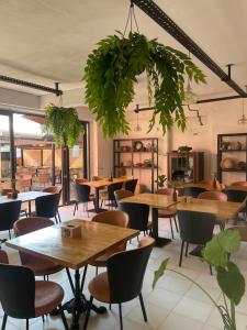 a restaurant with tables and chairs and plants at Olympia Ureki Guria Street 24-26 in Ureki