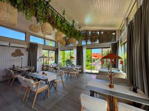 a restaurant with tables and chairs and large windows at Cirali Hestia Lodge in Kemer