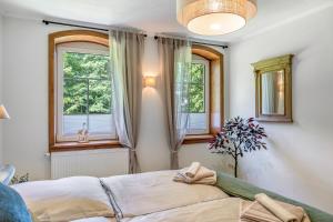 a bedroom with a bed and two windows at Ferienwohnung Schwarzmühle 2 in Neuer Anbau