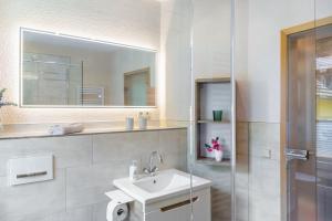 a white bathroom with a sink and a mirror at Ferienwohnung Schwarzmühle 2 in Neuer Anbau +28 photos
