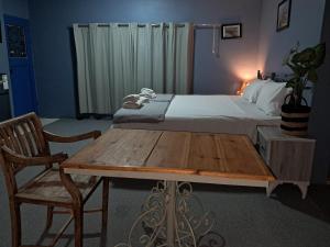 a bedroom with a bed and a wooden table and chair at Beit Philodemus 2 - IRIS in Um Qeis