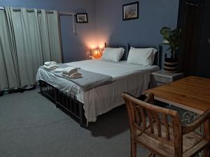 a bedroom with a large bed and a wooden table at Beit Philodemus 2 - IRIS in Um Qeis