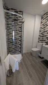 a bathroom with a glass shower and a toilet at Praciña do olvido in Cee +25 photos