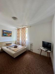 a bedroom with a bed and a flat screen tv at Hotel Gästehaus Altena in Altena