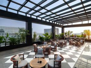 a restaurant with a checkered floor and tables and chairs at Pullman Chennai Anna Salai - Premium Brand By Accor in Chennai
