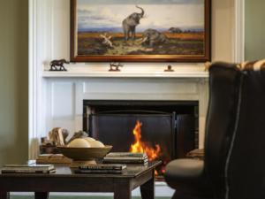 a living room with a fireplace with a table and a fire place at Founders Lodge by Mantis in Paterson