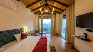 a hotel room with a large bed and a television at Cliffs & Clouds in Bhīm Tāl