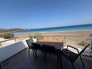 a balcony with a table and chairs and the beach at Korelis Apartments in Agia Anna