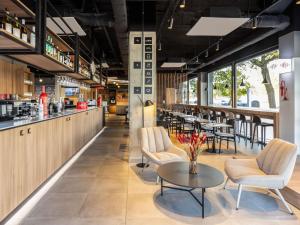 a restaurant with a table and chairs and a bar at ibis Madrid Norte Las Tablas in Madrid