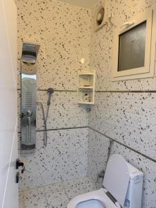 a small bathroom with a toilet and a phone at غرفة نوم 3 أسرّة مدخل خاص بدون صالة in Al Baha