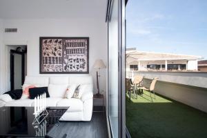 a living room with a white couch on a balcony at Atico Catedral Granada con parking in Granada