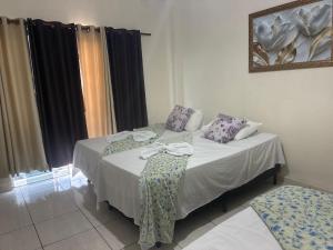 a room with a bed with a table and a mirror at Hospedagem da Néli 2 in Aparecida