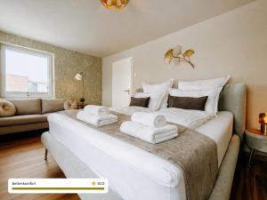 a bedroom with a large white bed with towels on it at Schäfers - Ihr Wohlfühlort, Ferienwohnungen & Ferienhaus am Naturteich an 2 Seen bei Leipzig in Großpösna