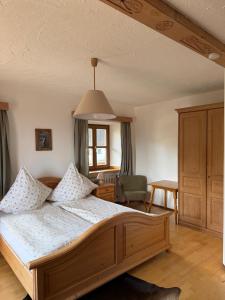 a bedroom with a large bed and a chair at Schwaigerhof Rottau in Rottau