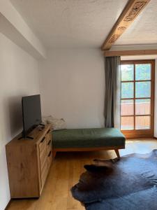 a room with a green bed and a tv and a window at Schwaigerhof Rottau in Rottau
