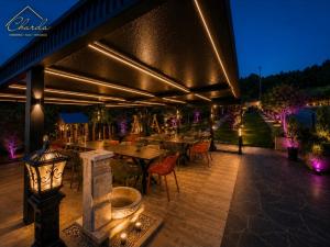 an outdoor patio with tables and chairs and lights at Charda Guesthouse in Laktaši