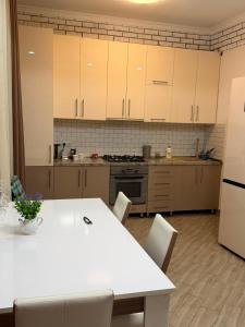 a kitchen with a white table and a white refrigerator at Edle Tropfen in Tqibuli