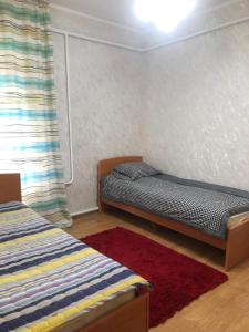 a bedroom with two beds and a window at Чолпон-Ата Коттедж in Cholpon-Ata