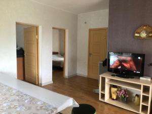 a living room with a television and a bedroom at Чолпон-Ата Коттедж in Cholpon-Ata