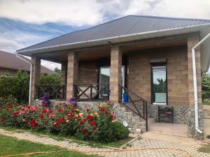 a small house with flowers in front of it at Чолпон-Ата Коттедж in Cholpon-Ata