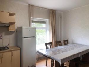 a kitchen with a table and a white refrigerator at Чолпон-Ата Коттедж in Cholpon-Ata