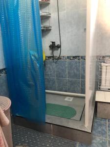 a shower with a blue shower curtain in a bathroom at Чолпон-Ата Коттедж in Cholpon-Ata +10 photos