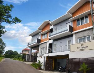 a building with a sign in front of it at Srj's Thaneesh Residency in Ooty