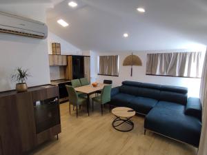 a living room with a blue couch and a table at Deluxe Dino room & studio apartment by Adex travel in Zadar