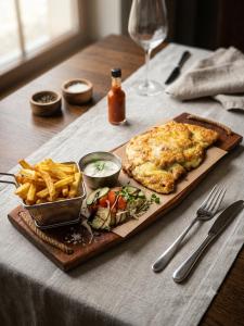 a cheese pizza and french fries on a table at Queens Safehouse in Brozany