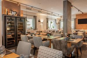 a restaurant with tables and chairs in a room at Hotel Almrausch in Saalbach-Hinterglemm
