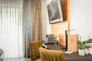 a desk with a computer and two chairs in a room at Hotel Almrausch in Saalbach-Hinterglemm