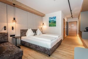 a hotel room with a bed and a couch at Hotel Almrausch in Saalbach-Hinterglemm